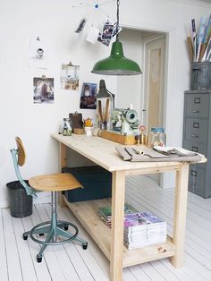 a room with a desk, chair and hanging light in it's center area