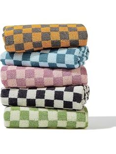 four towels stacked on top of each other in different colors and patterns, with one folded up