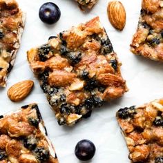 several pieces of fruit and nuts are arranged on a sheet of parchment paper with almonds