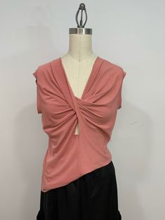 Sleeveless comfortable twist top made out of pink knit fabric. The front twist gives the top a very flattering look.  The T-shirt feels very soft to the touch and looks very elegant. It can be worn with any skirts or jeans. Bust  38 inches  Length  25 inches Fits  M Summer V-neck Twist Front Tops, Versatile Stretch Pink Tops, Versatile Pink Stretch Tops, Pink Fitted Sleeveless Top, Pink Fitted Knit Top, Sleeveless Summer Top With Knot Detail, Pink Stretch Sleeveless Top, Pink Sleeveless Stretch Top, Versatile Twist Front Top For Summer