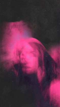 a blurry image of a person with long hair and pink light in the background