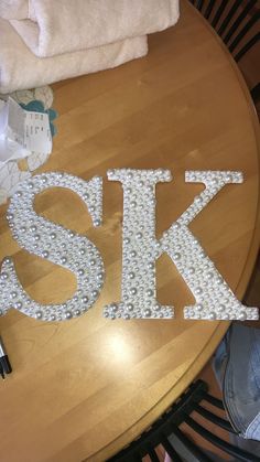 the letters are made out of beads on top of a table with towels and other items