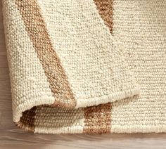 a close up of a rug on a wooden floor with wood grains and lines