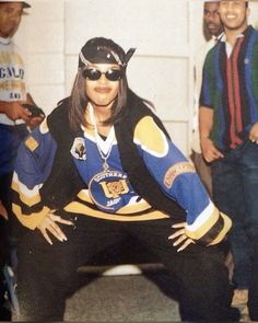 a woman in a hockey uniform poses for a photo with other people behind her,