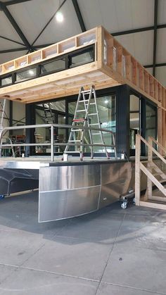 a large metal boat sitting inside of a building next to some stairs and railings