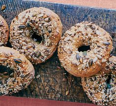 several bagels with sesame seeds are on a cutting board