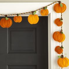 a black door with pumpkins hanging from it