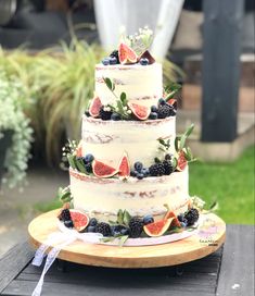 a three tiered cake with fresh fruit on top