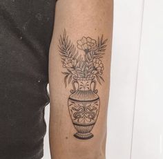 a black and white photo of a vase with flowers in it on the left arm