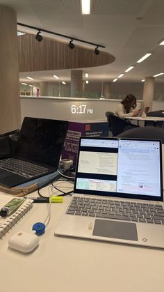 an open laptop computer sitting on top of a white desk next to a mouse and keyboard