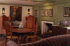 a living room filled with furniture next to a fire place and painting on the wall