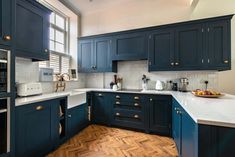 a kitchen with blue cabinets and white counter tops