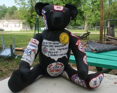 a teddy bear that is sitting on a table in front of a picnic table and bench