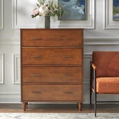 a wooden dresser sitting next to an orange chair