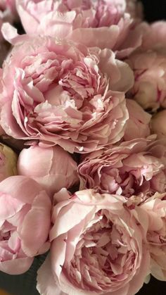 a bouquet of pink peonies with a smiley face drawn on the top one