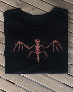 a black t - shirt with an image of a skeleton on it