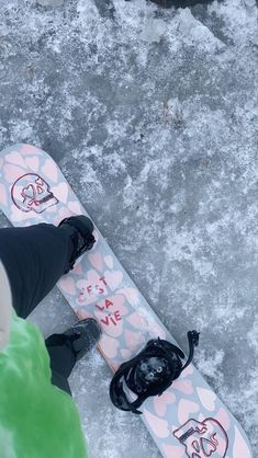 a person standing next to a snowboard on top of frozen ground with the words let it snow