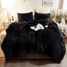 a bed with black comforters and pillows in a room