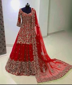 a red bridal gown on display in a room with white walls and flooring