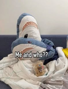 a stuffed shark sitting on top of a blue couch next to a yellow banana peel