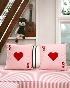 two pillows with playing cards on them sitting on a bed