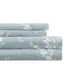 three sheets with blue and white floral designs on the bottom, one is folded in half