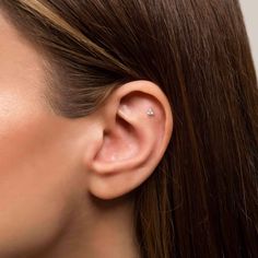 a close up of a person wearing a pair of ear piercings on their ears