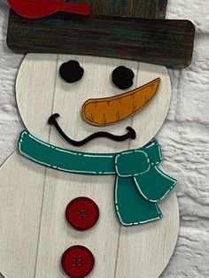 a snowman with a hat and scarf on it's head is made out of wood