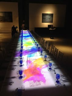 a long table is lit up with bright colors