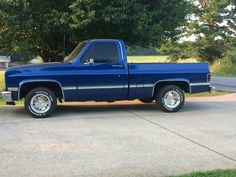 a blue pick up truck parked in a driveway