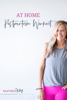 a woman standing in front of a white wall with the words at home written on it