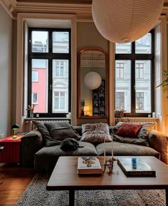 a living room filled with furniture and lots of window sill space next to a coffee table