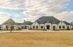 a large white house sitting on top of a dry grass field