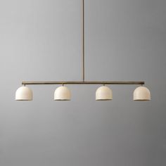 three lights hanging from a ceiling fixture in a room with gray walls and flooring