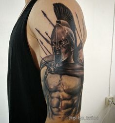 a man with a spartan tattoo on his arm