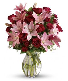 a vase filled with lots of pink and red flowers