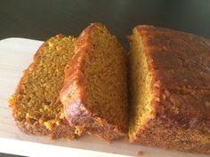 a loaf of bread sitting on top of a cutting board next to a slice of cake