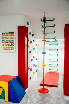 an indoor play area with climbing ropes and colorful blocks on the floor, in a children's room