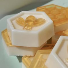 some soaps are sitting on a white plate with honeycombs in the middle