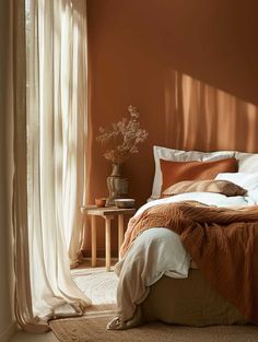 a bedroom with an orange wall and white curtains