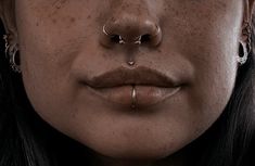 a woman with piercings on her nose and nose ring