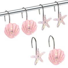 four pink sea shells and starfish hooks on a metal bar, with glitter stars