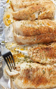 two fish fillets on foil with a fork