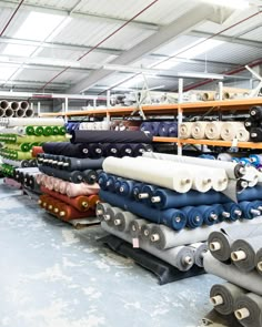 many rolls of fabric are lined up in a warehouse