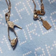 two necklaces on a blue fabric with white dots and small squares in the background