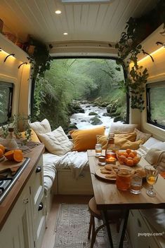 the interior of a camper with an open kitchen and dining table in front of it