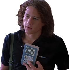 a young man holding up a book in front of his face