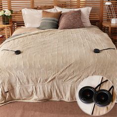 a bed with headphones on it and some pillows in front of the bedspread