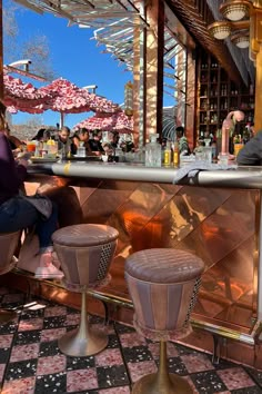 two people sitting at a bar with stools