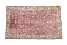 an antique rug with pink and white colors